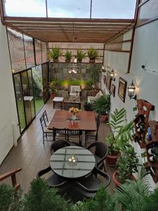 an outdoor patio with tables and chairs and plants at Hospedaje en Quito Norte, Apartamento & Suite independientes in Quito