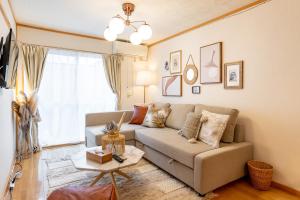 ein Wohnzimmer mit einem Sofa und einem Tisch in der Unterkunft Type C Room 40平米 -ウル エスポワール那覇- in Kume