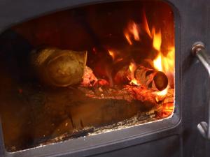 a fire oven with food cooking in it at Guest House Honami-Kaido in Yamanouchi