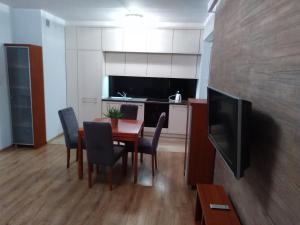 a kitchen with a table and chairs and a television at Apartament MAZURIA2 in Ełk