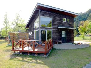 eine kleine Blockhütte mit einer großen Terrasse in der Unterkunft Mt Ichibata Cottage in Izumo
