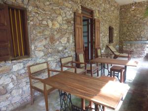 a room with wooden tables and chairs in a stone wall at Lanrich Eco Villas in Mirissa +39 photos