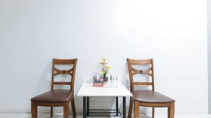 dwa krzesła siedzące obok stołu z białym stołem w obiekcie RedDoorz near SM Calamba w mieście Laguna