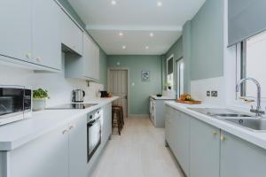 a kitchen with white countertops and green walls at BRAND NEW TOWNHOUSE IN RUGBY in Rugby