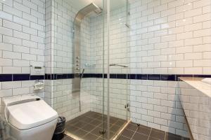 a bathroom with a toilet and a glass shower at 朵兒dor韓國汗蒸幕 동대문점 商務旅店 in Taipei