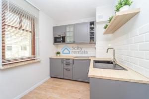 a kitchen with a sink and a counter top at Botanika Deluxe Apartment Sopot in Sopot