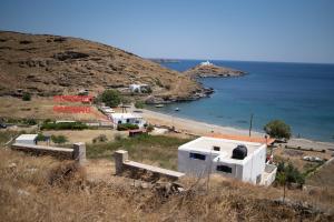 um grupo de edifícios numa colina junto ao oceano em House by the sea em Kythnos