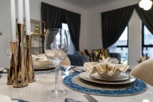 a dining room table with a plate and a wine glass at Durrani Homes - Old Town Lux 1 bed Besides Dubai Mall in Dubai