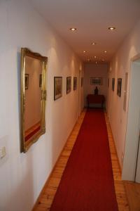 a long hallway with a red carpet and a mirror at Gutshof Eucken in Algermissen