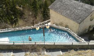a man is standing in a large swimming pool at B&B da Lori in Tirano