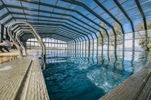 a swimming pool with a glass ceiling and water at Park Hotel Tsinandali Estate in Tsinandali