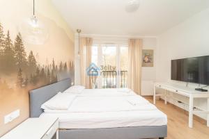 a bedroom with two beds and a flat screen tv at Aura Sopot Studio Apartments in Sopot
