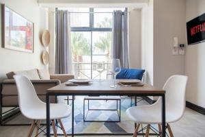 uma sala de estar com uma mesa de jantar e cadeiras em The Square Holiday Apartments em Cidade do Cabo