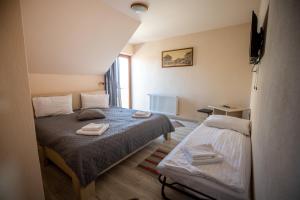 a bedroom with a bed with two towels on it at DUNESDORFER PENSION in Daneş