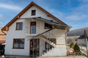 a white house with a staircase in front of it at DUNESDORFER PENSION in Daneş