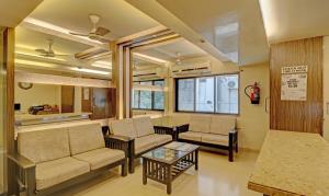uma sala de estar com sofás e uma mesa em Treebo Trend Vikrant Residency em Pune