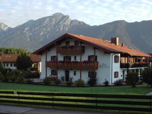 Casa blanca con balcón y montañas de fondo en Gut Fallenstein, en Bayerisch Gmain