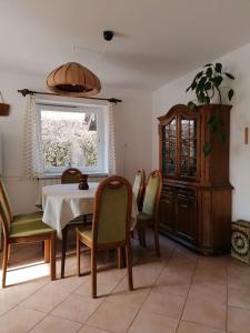 comedor con mesa, sillas y ventana en Ágnes Nyaralóház, en Zalakaros