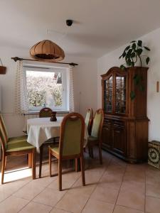 a dining room with a table and chairs and a window at Ágnes Nyaralóház in Zalakaros