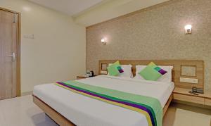 um quarto com uma grande cama branca com almofadas coloridas em Treebo Trend Vikrant Residency em Pune