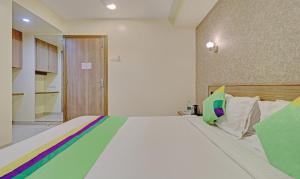 a bedroom with a large bed with colorful sheets at Treebo Trend Vikrant Residency in Pune