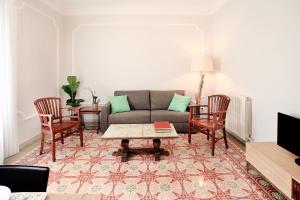 een woonkamer met een bank en stoelen bij Casa Valeta in Barcelona