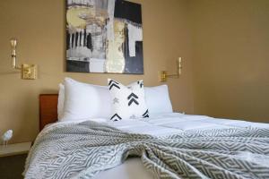 ein Bett mit weißer Bettwäsche und Kissen in einem Schlafzimmer in der Unterkunft Sleepover 1BD 1BA Downtown Wichita Apartments in Wichita
