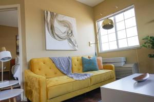 ein Wohnzimmer mit einem gelben Sofa und einem Fenster in der Unterkunft Sleepover 1BD 1BA Downtown Wichita Apartments in Wichita