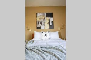 a bedroom with a bed with white sheets and pillows at Sleepover 1BD 1BA Downtown Wichita Apartments in Wichita