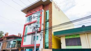 ein farbenfrohes Gebäude an der Ecke einer Straße in der Unterkunft RedDoorz near Talisay District Hospital in Candulawan