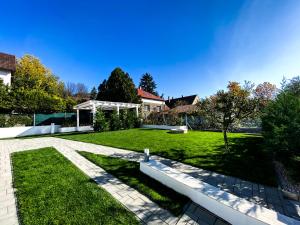 a house with a lawn with a pathway at Shambala Apartman Tihany in Tihany