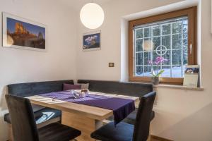 d'une table à manger et de chaises avec un chiffon de table violet dans l'établissement Ferienwohnung Hirzer Edelweiss, à Avelengo