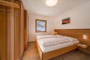 - une chambre avec un lit et une tête de lit en bois dans l'établissement Ferienwohnung Hirzer Edelweiss, à Avelengo