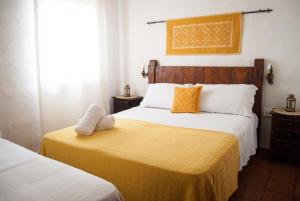 um quarto com 2 camas e um cobertor amarelo em Villa Bados 6 - Klodge em Olbia