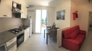 een keuken met een rode bank en een rode stoel bij Residenza VerdeMare in Misano Adriatico