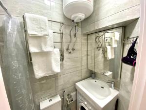 La salle de bains est pourvue d'un lavabo, de toilettes et d'un miroir. dans l'établissement Deribasovskaya Center Apartment, à Odessa