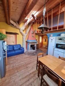 a kitchen and living room with a blue couch and a table at Casa della Casa in San Severino Marche