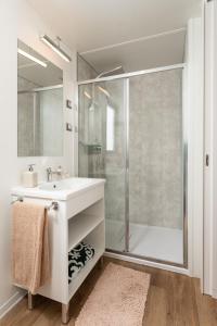uma casa de banho branca com um lavatório e um chuveiro em Camping Village Riviera em Numana