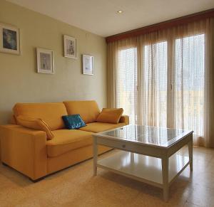 ein Wohnzimmer mit einem Sofa und einem Couchtisch in der Unterkunft Apartament Mia in Deltebre