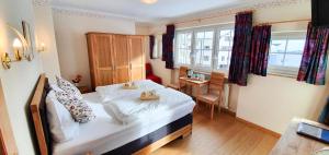 a small bedroom with a bed and a desk at Hotel Tauernglöckl in Obertauern