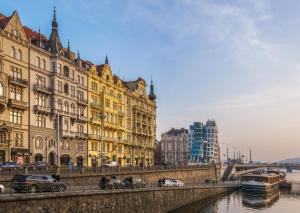 eine Gruppe von Gebäuden neben einem Fluss mit einer Brücke in der Unterkunft MN6 Luxury Suites by Adrez in Prag