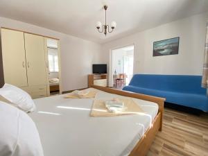 a bedroom with a large bed and a blue couch at Guest House Dijana in Krk