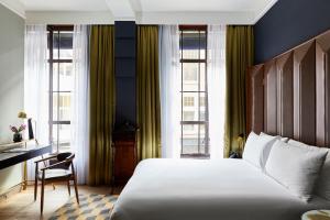 Schlafzimmer mit einem Bett, einem Schreibtisch und Fenstern in der Unterkunft Hotel Indigo The Hague - Palace Noordeinde, an IHG Hotel in Den Haag
