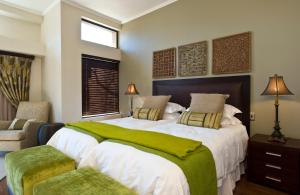 a bedroom with a large bed with a green blanket at Legend Golf and Safari Resort in Sterkrivier