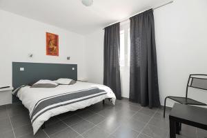 a bedroom with a large bed and a window at H&ocirc;tel Restaurant le Voilis in Le Grau-dʼAgde
