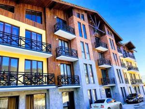 a building with balconies and a car parked in front of it at Park Residence Forest View in Bakuriani