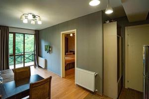 a living room with a table and a room with a bed at Park Residence Forest View in Bakuriani