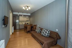 a living room with a couch and a dining room at Park Residence Forest View in Bakuriani