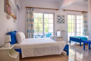 ein Schlafzimmer mit einem großen Bett mit blauen Akzenten in der Unterkunft Faros Rooms in Livadia