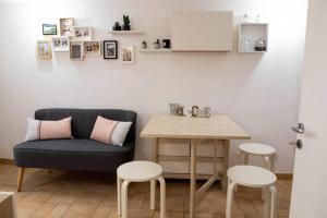 a living room with a table and a couch and stool at La Casetta - Casa Indipendente nel centro storico in Fermo